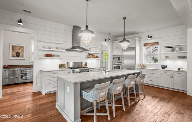 575 Distant Island Dr, Beaufort, SC 29907 - kitchen with open shelves, built in appliances, wall chimney exhaust hood, beverage cooler, and hardwood / wood-style flooring