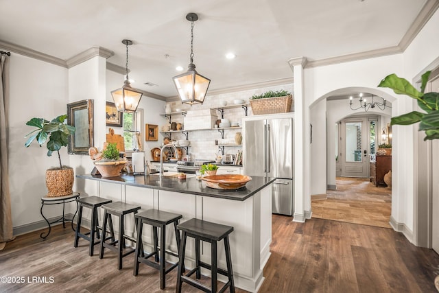 15 Sunset Blvd Unit 1201, Beaufort, SC 29907 - kitchen featuring high end fridge, dark countertops, crown molding, a peninsula, and arched walkways