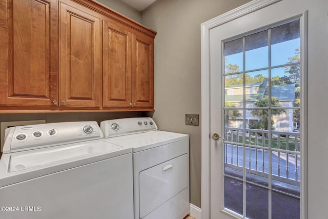 clothes washing area with cabinets and separate washer and dryer