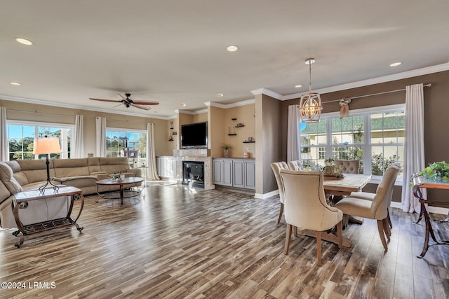 dining room with hardwood / wood-style flooring, ceiling fan with notable chandelier, and ornamental molding