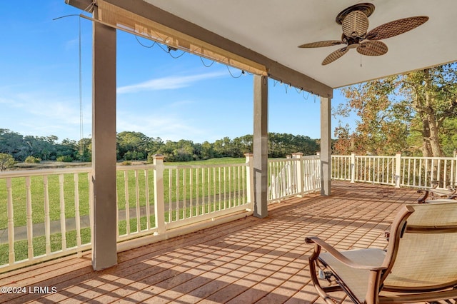 wooden deck featuring a yard and ceiling fan