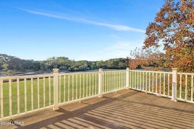 wooden deck featuring a rural view and a lawn