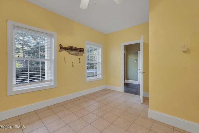 tiled spare room featuring ceiling fan