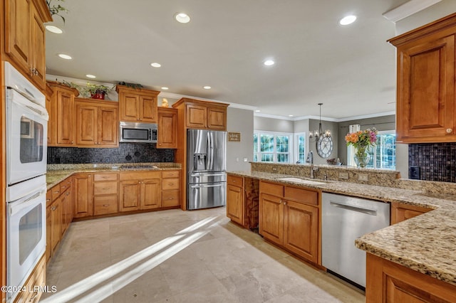 kitchen featuring pendant lighting, sink, backsplash, and stainless steel appliances