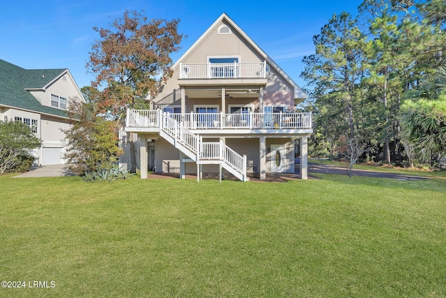 rear view of property with a wooden deck, a yard, a balcony, and ceiling fan