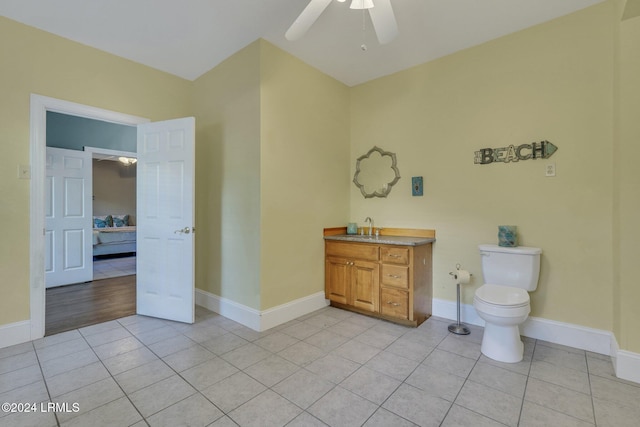 bathroom featuring tile patterned flooring, vanity, ceiling fan, and toilet