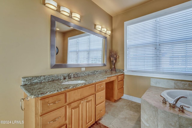 bathroom with tile patterned floors, tiled bath, vanity, and plenty of natural light