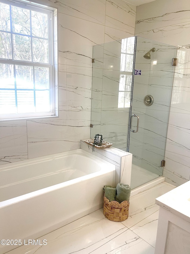 bathroom featuring marble finish floor, a shower stall, a bath, and vanity