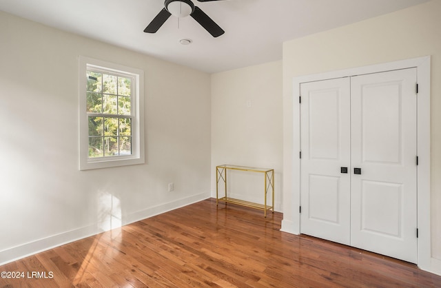 unfurnished bedroom with a ceiling fan, a closet, baseboards, and wood finished floors