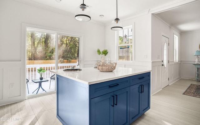 kitchen with crown molding, a kitchen island, decorative light fixtures, and blue cabinets