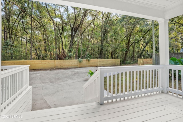 wooden terrace with a fenced backyard