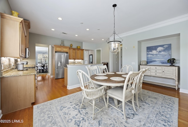 dining area featuring ornamental molding, sink, and light hardwood / wood-style flooring