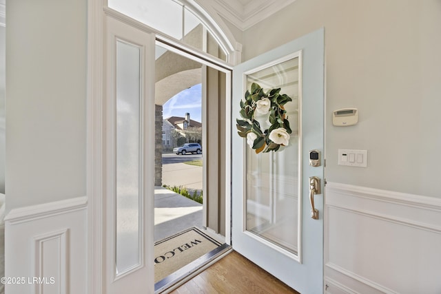 foyer with wood-type flooring and ornamental molding