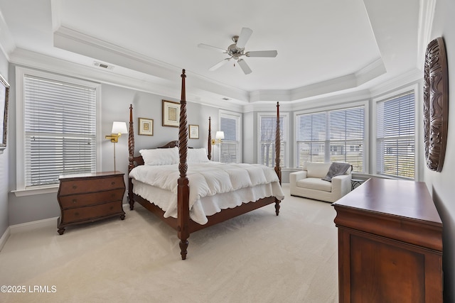 bedroom featuring crown molding, light carpet, and a tray ceiling