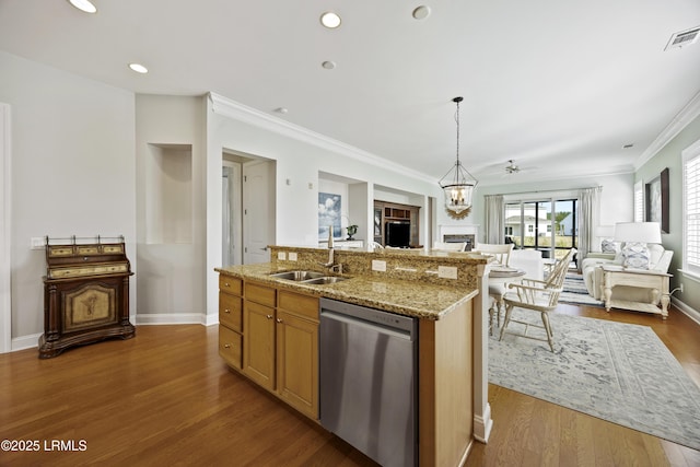 kitchen featuring sink, wood-type flooring, stainless steel dishwasher, an island with sink, and pendant lighting