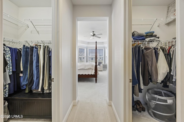 spacious closet with light carpet and ceiling fan