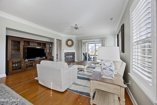 living room with hardwood / wood-style flooring, ornamental molding, and ceiling fan