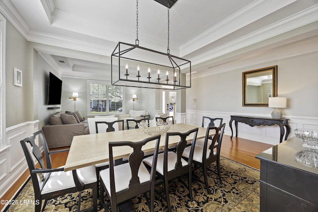 dining room with ornamental molding, a tray ceiling, and hardwood / wood-style floors