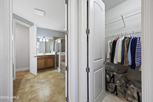 bathroom featuring vanity, tile patterned flooring, and walk in shower