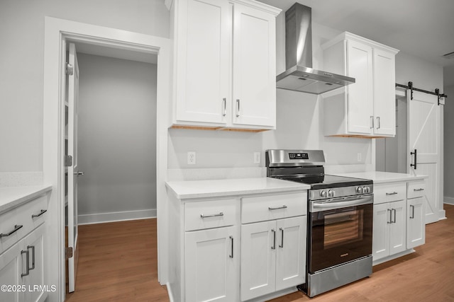 12 Meagan Dr, Beaufort, SC 29907 - kitchen with stainless steel electric range oven, wall chimney range hood, light wood finished floors, and white cabinetry