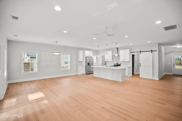 12 Meagan Dr, Beaufort, SC 29907 - kitchen featuring appliances with stainless steel finishes, wall chimney exhaust hood, a barn door, open floor plan, and recessed lighting