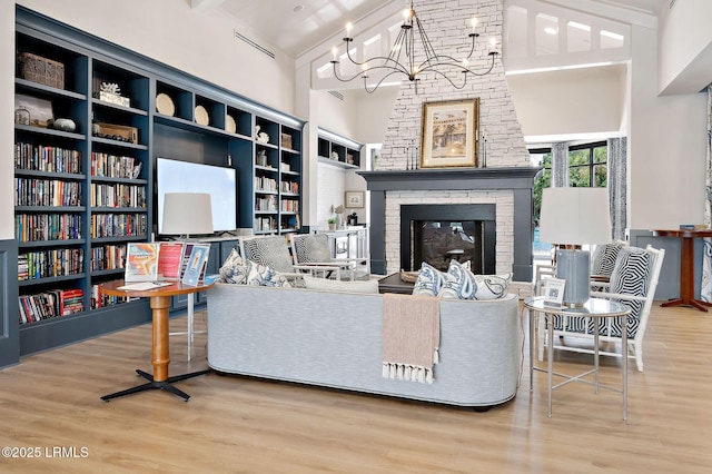 21 Heathrow Ave, Bluffton, SC 29910 - living room featuring wood finished floors, high vaulted ceiling, a fireplace, and a chandelier