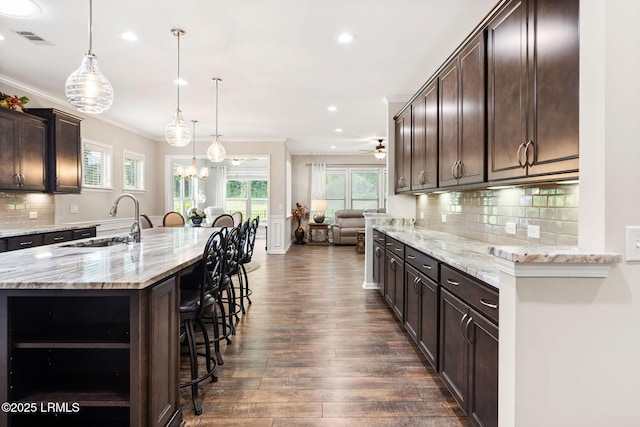 21 Heathrow Ave, Bluffton, SC 29910 - kitchen featuring a kitchen bar, recessed lighting, dark wood-type flooring, open floor plan, and dark brown cabinetry