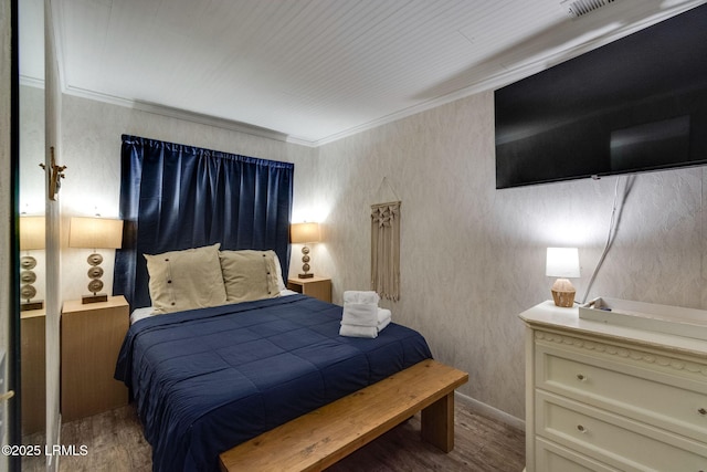 bedroom with baseboards, wood finished floors, and crown molding