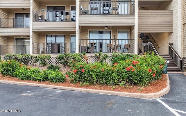 view of property featuring uncovered parking and stairway