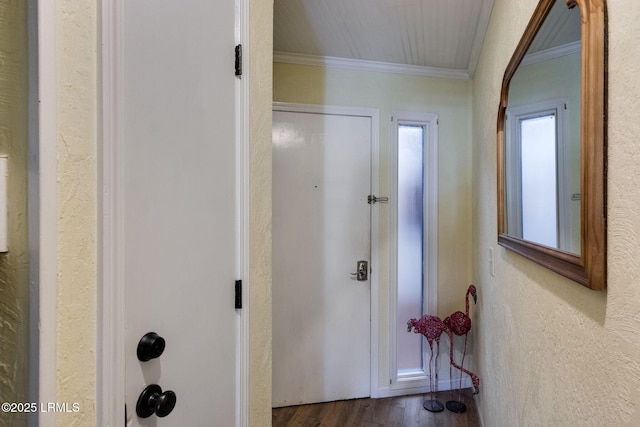 corridor featuring ornamental molding, wood finished floors, and a textured wall