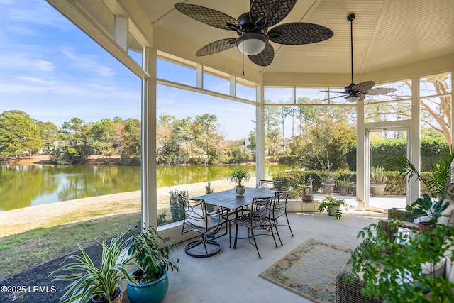 sunroom / solarium featuring a water view and ceiling fan