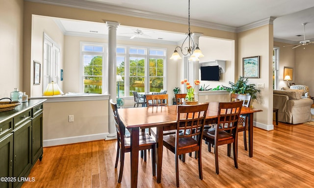 dining room featuring crown molding, ceiling fan, decorative columns, and light hardwood / wood-style flooring