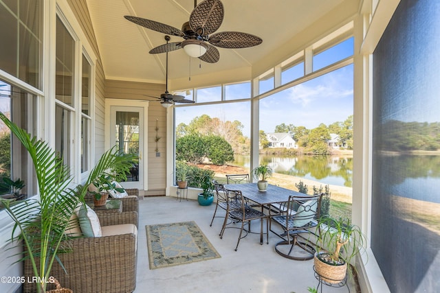 sunroom featuring a water view and ceiling fan