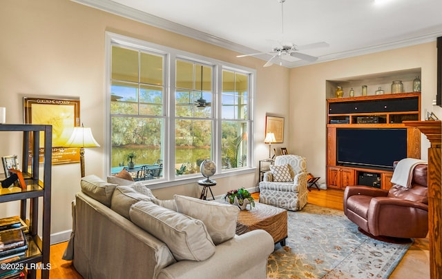 living room with ornamental molding, light hardwood / wood-style floors, and ceiling fan