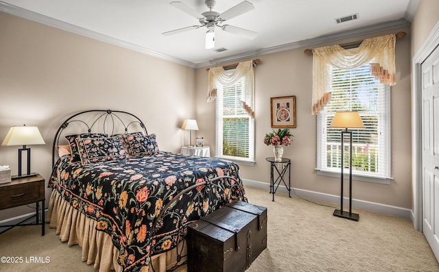 carpeted bedroom with ornamental molding, ceiling fan, and a closet