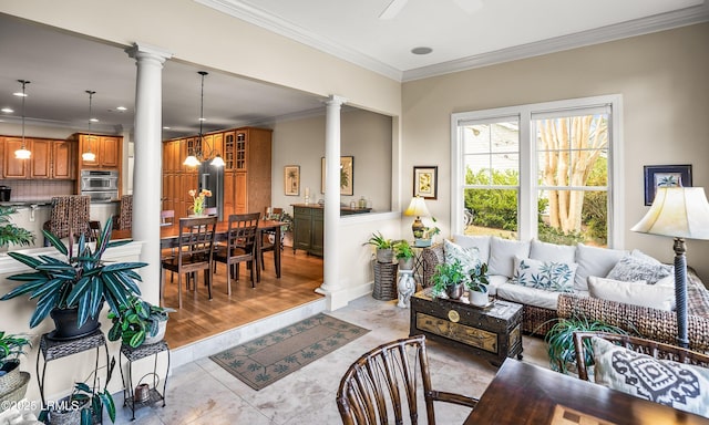 living room with crown molding, ceiling fan, and decorative columns