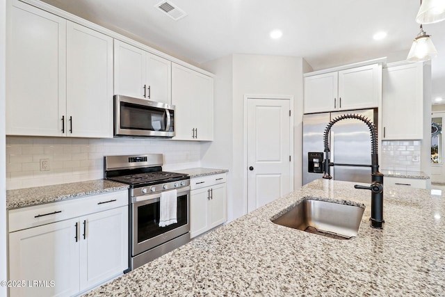 kitchen featuring stainless steel appliances, white cabinetry, and sink