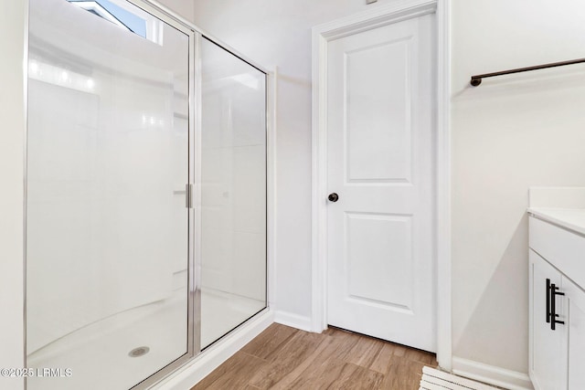 bathroom with vanity, wood-type flooring, and a shower with door