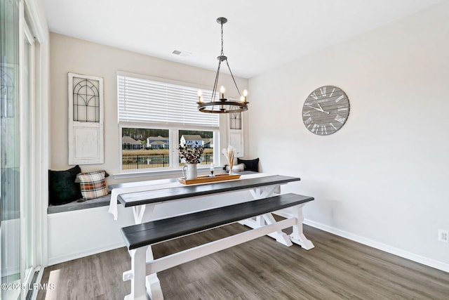 dining space with breakfast area, wood-type flooring, and an inviting chandelier