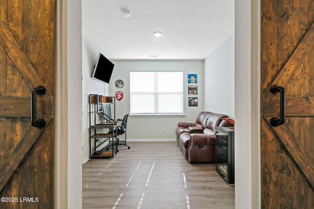 office featuring light hardwood / wood-style floors and a barn door