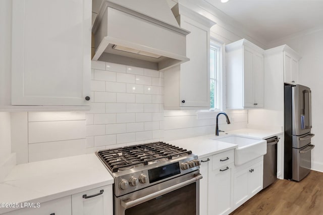 kitchen with tasteful backsplash, appliances with stainless steel finishes, custom range hood, and white cabinets