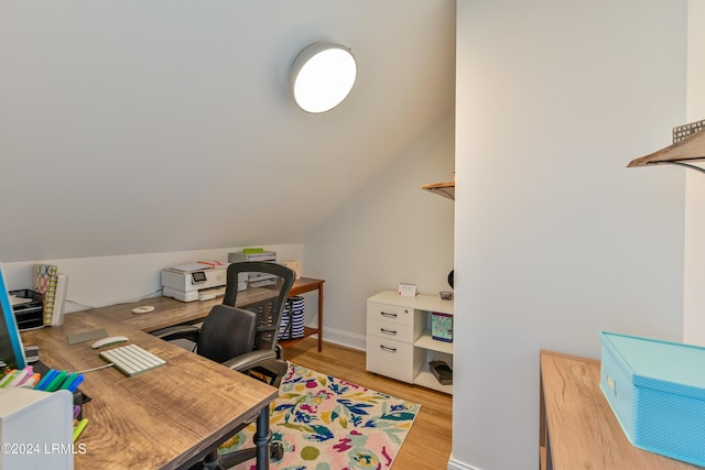 home office featuring lofted ceiling and light hardwood / wood-style flooring