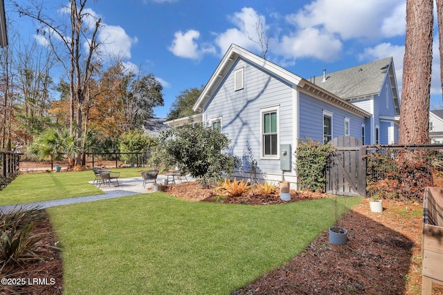 view of property exterior featuring a patio area and a lawn