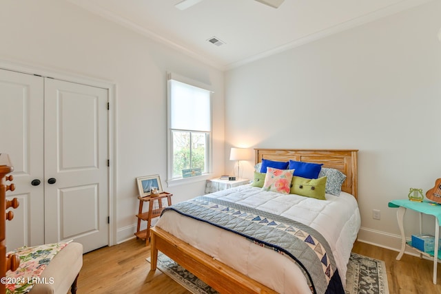 bedroom with crown molding, a closet, and light wood-type flooring