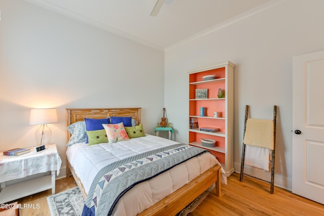 bedroom with ceiling fan, ornamental molding, and hardwood / wood-style floors