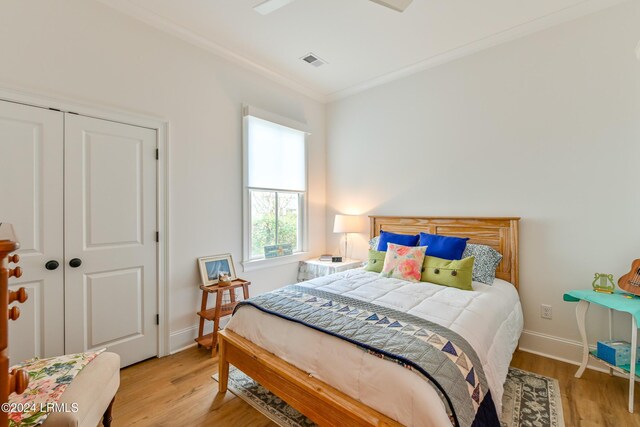 bedroom with ornamental molding, a closet, ceiling fan, and light wood-type flooring