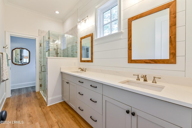 bathroom featuring vanity, crown molding, a shower with shower door, and hardwood / wood-style flooring