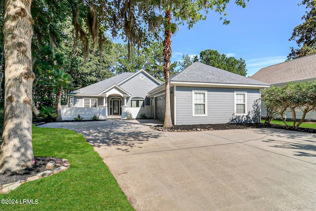 single story home featuring a garage and a front yard