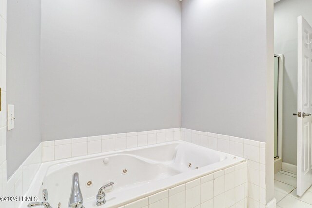 bathroom featuring tiled bath and tile patterned flooring