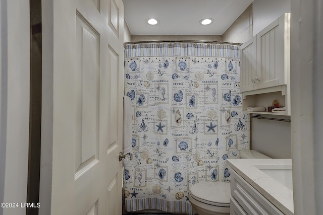 bathroom featuring vanity, curtained shower, and toilet